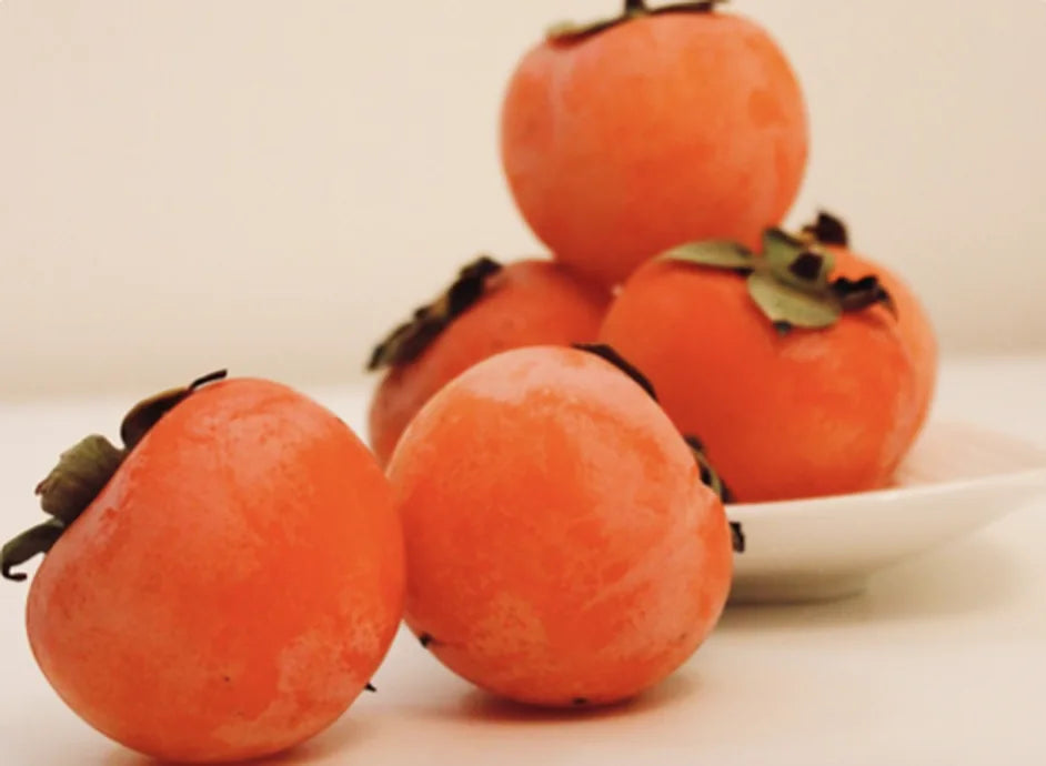 Ripe persimmons on a white plate