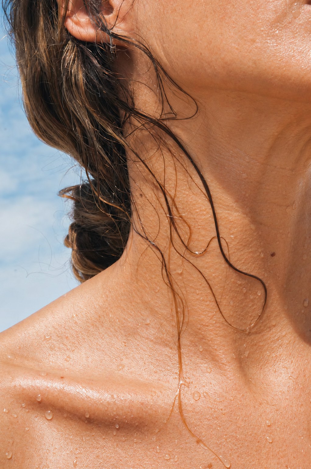 Close-up of a woman's neck and shoulder with water droplets after a shower